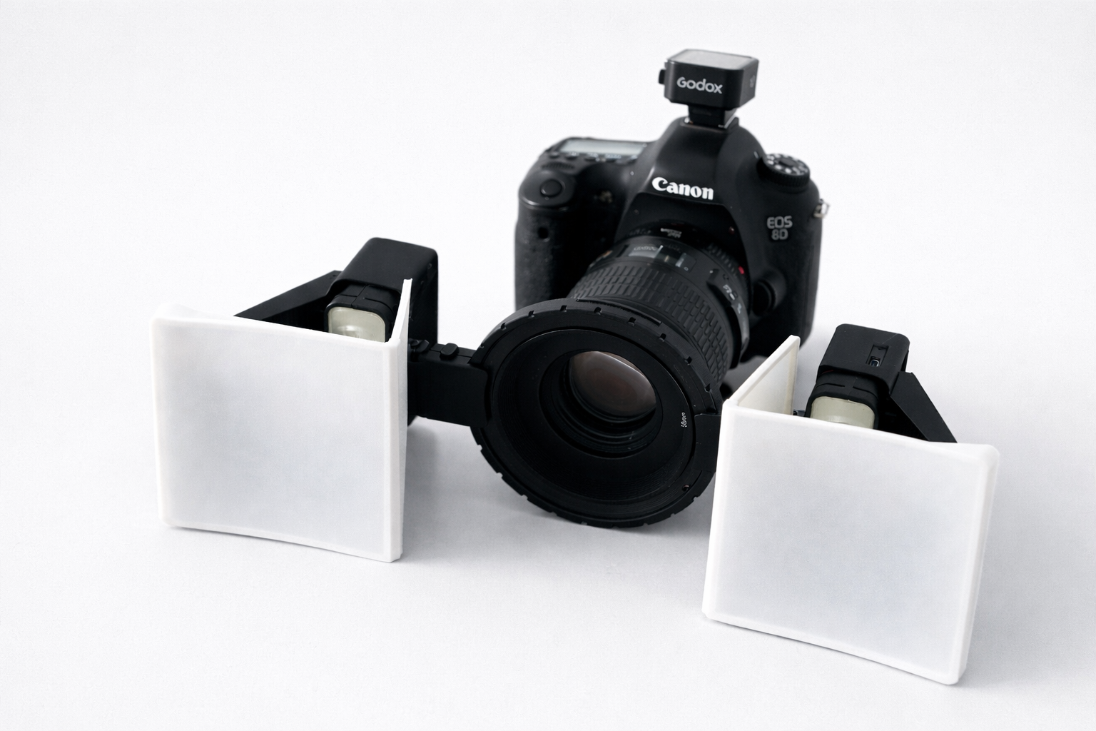 Canon camera with lens cleaning brushes on a white background